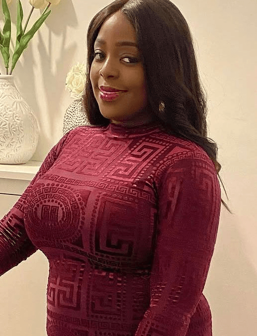 Bola, behaviour specialist and SEN learning support assistant, in a burgundy patterned top, smiling.