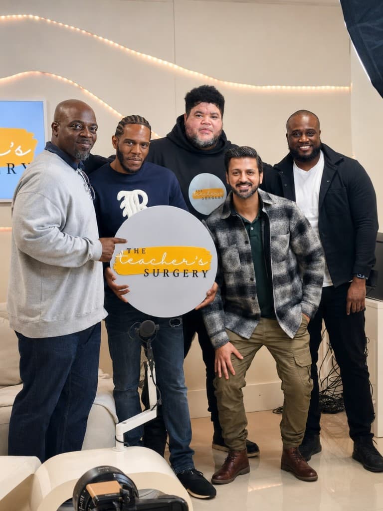 Five members of The Teacher's Surgery team in the studio, holding the circular brand sign